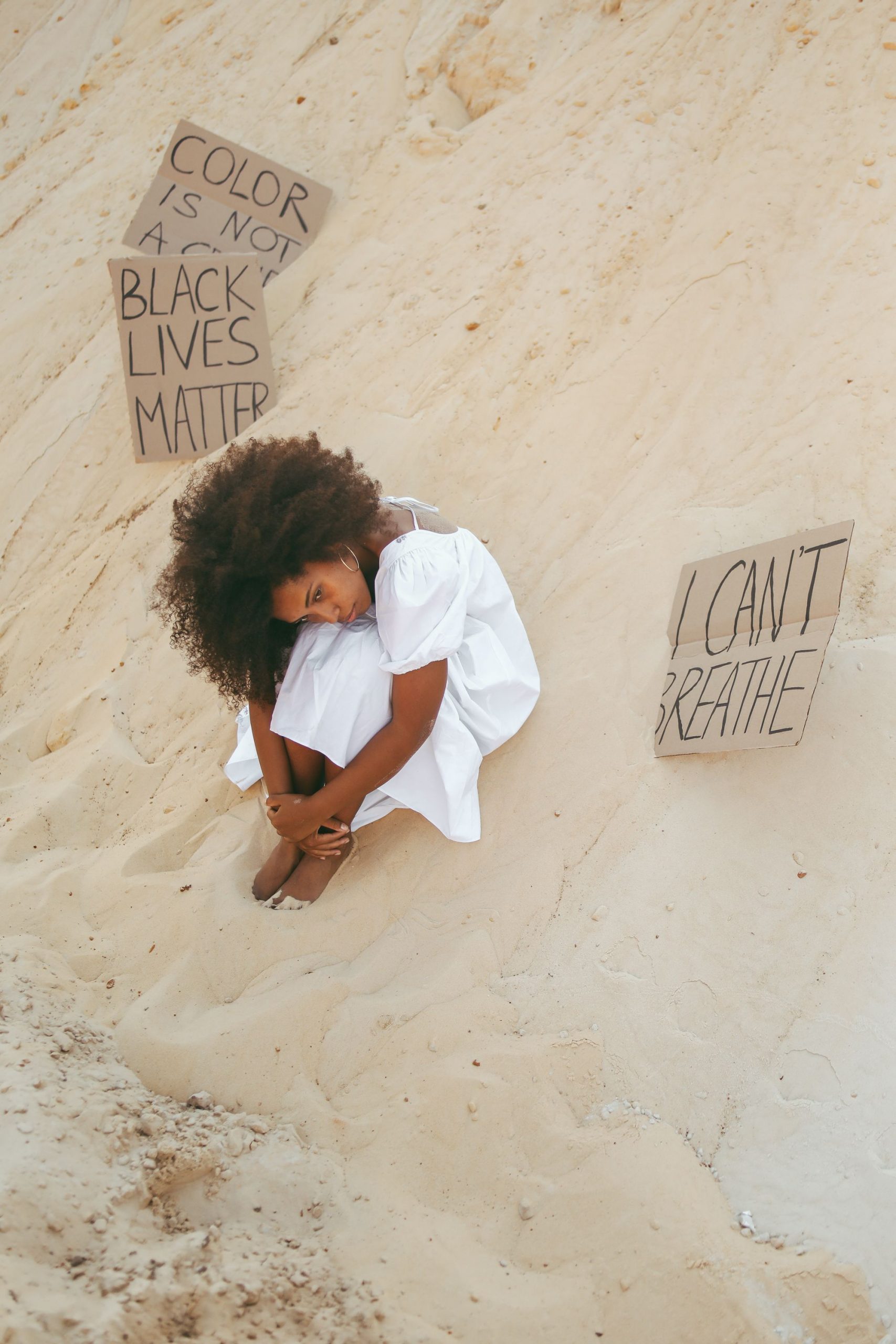 Black woman sitting thoughtfully, reflecting on stress and wellness challenges facing the Black community in 2026