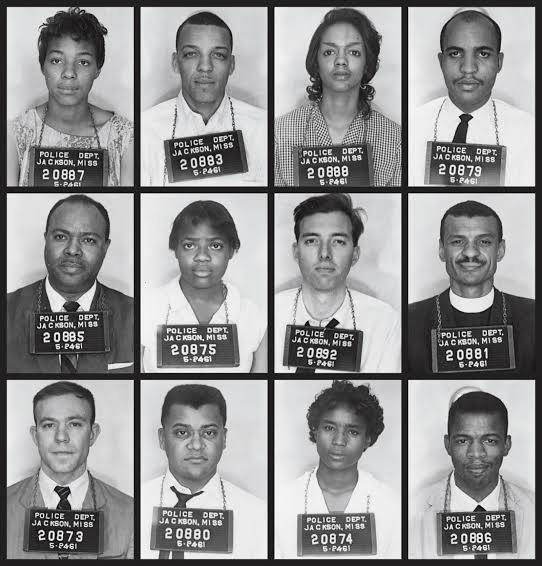 Grid of sixteen black-and-white mugshots (4x4) of individuals in a police lineup, each holding a placard with 'POLICE DEPT. JACKSON, MISS' and a numeric ID.